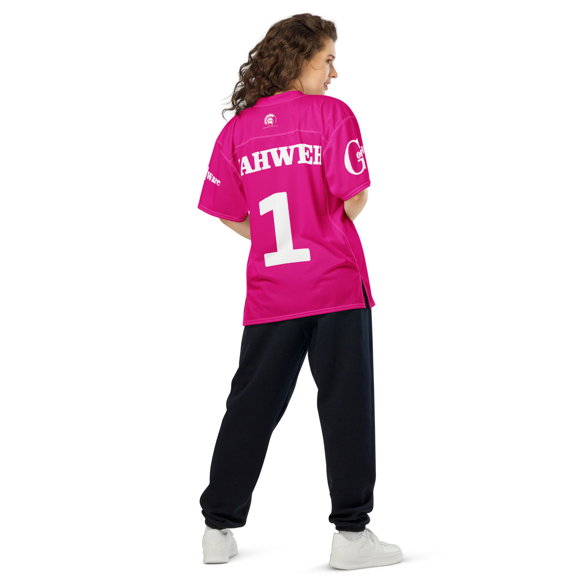 Yahweh Christian Football Jersey in bright pink, featuring white 'YAHWEH 1' on the back, styled with black pants.