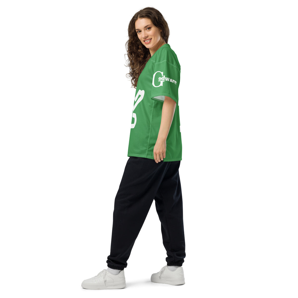 Woman wearing a green Yahweh Christian football jersey styled with black pants, showcasing a casual look.