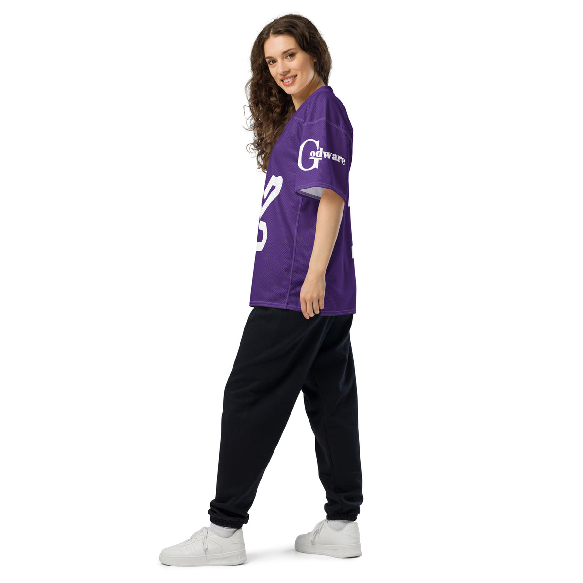 Woman wearing a Yahweh Christian football jersey in purple and white, styled with black pants.