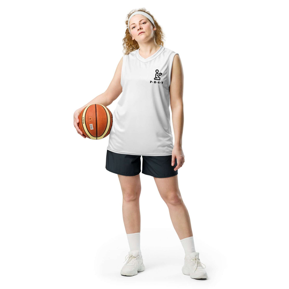 Model wearing a white Pray Christian recycled mesh basketball jersey and holding a basketball.